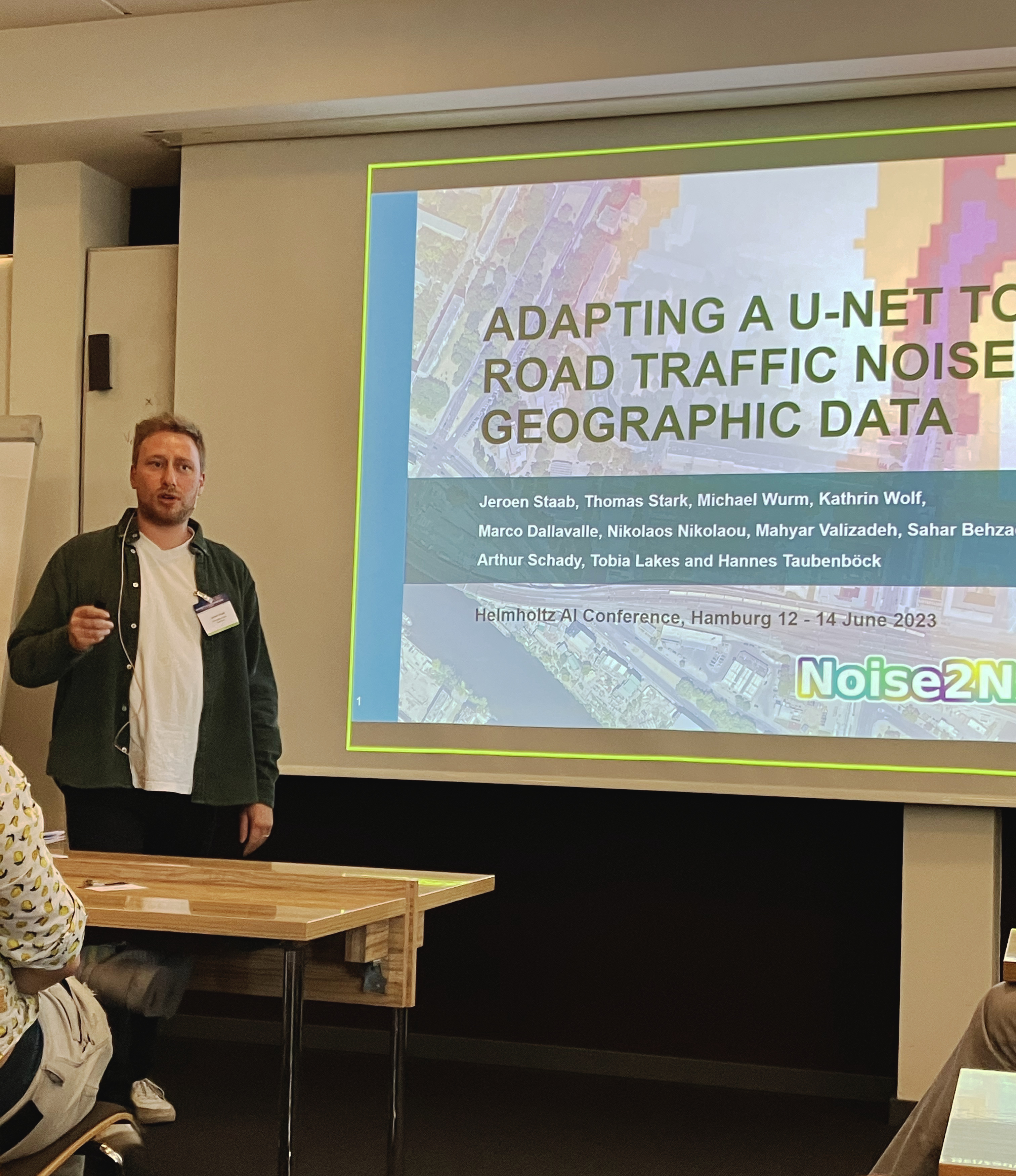 Jeroen Staab, male person wearing green shirt, presenting at Helmholz AI conference in Hamburg 2023.